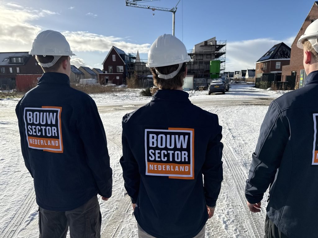 Drie vakmensen van Bouwsector Nederland met witte helm voor woningen in aanbouw